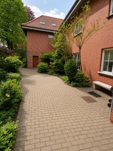 a brick house with a brick walkway next to a building at Apartment Rahden in Rahden