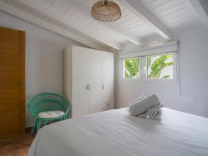 a bedroom with a white bed and a green chair at Oasis Beach Holiday Home with jacuzzi in Playa del Ingles +68 photos