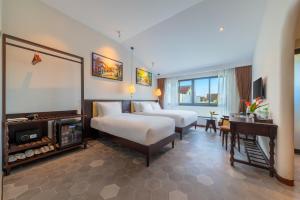 a hotel room with two beds and a desk at BACKHOME BOUTIQUE Old Town Hoi An in Hoi An +36 photos