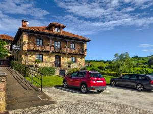 two cars parked in front of a house at Posada La Solana Santillana del Mar in Santillana del Mar