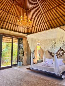 a bedroom with a bed with curtains and a chandelier at Akasha New Earth Haven Villa in Ubud +113 photos