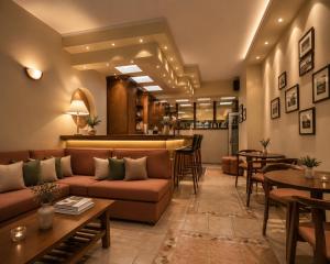 a lobby with a couch and tables and a bar at Hotel Dionysis Studios in Adamantas