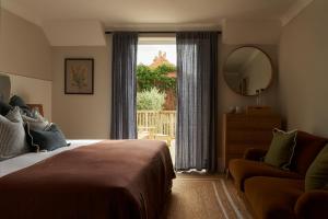 a bedroom with a bed and a mirror and a window at Lulworth Lodge in Lulworth Cove