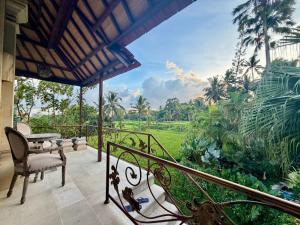 a house with a balcony with a view of a garden at Akasha New Earth Haven Villa in Ubud