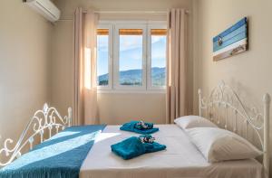 a bedroom with a bed with blue towels on it at Family Heritage Homes- Skiathos in Skiathos