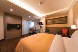 a bedroom with a large bed and a flat screen tv at Sir Motel - Sanchong in Taipei