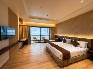 a hotel room with a bed and a television at The Lynora in Mysore +55 photos