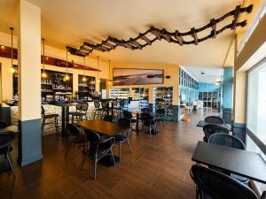 ein Restaurant mit Tischen und Stühlen und einer Bar in der Unterkunft HS Milfontes Beach Hotel - Duna Parque Group in Vila Nova de Milfontes