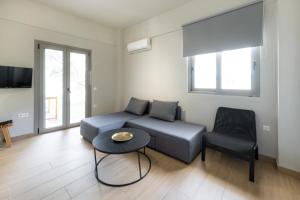 a living room with a couch and a table and a chair at DION APARTMENTS in Paleros