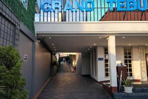 a woman walking down a hallway in a building at Subwow Hostel in Bandung