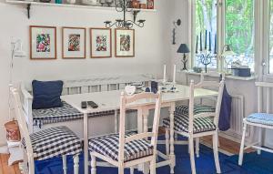 a dining room with a white table and chairs at Cozy Home In Sölvesborg With Wifi in Sölvesborg