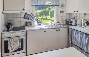 a kitchen with white appliances and a sink and a window at Cozy Home In Sölvesborg With Wifi in Sölvesborg