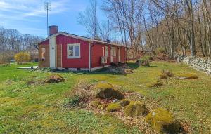 a small red house in the middle of a field at Cozy Home In Sölvesborg With Wifi in Sölvesborg