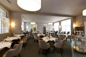 a restaurant with tables and chairs in a room at Seehotel Ecktannen in Waren