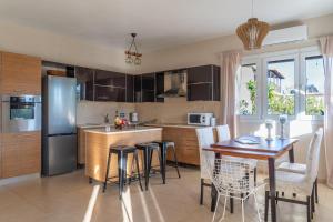 a kitchen with a table and chairs and a refrigerator at Family Heritage Homes- Skiathos in Skiathos