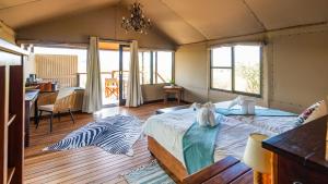a bedroom with two beds and a desk and a table at Windhoek Game Camp in Lafrenz Township