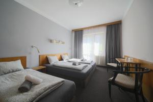 a hotel room with two beds and a desk at Star Hotels Benecko in Benecko