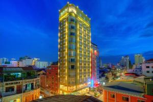 a tall yellow building in a city at night at Orussey One Hotel & Apartment in Phnom Penh