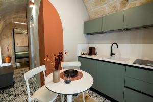 a small kitchen with a table and a sink at Aria d'amare in Mola di Bari