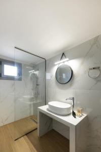 a white bathroom with a sink and a mirror at DION APARTMENTS in Paleros +37 photos