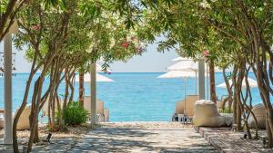 a beach with chairs and umbrellas and the ocean at Casa Solea in Barbati