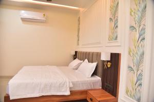 a bedroom with a bed with white sheets at Radiant Inn in Morena +5 photos