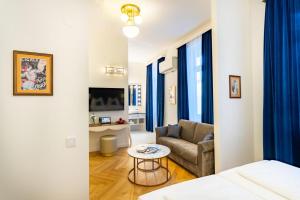 a living room with a couch and a table at Theaterhotel & Suites Wien in Vienna +63 photos
