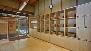 a room with shelves and a clock on the wall at Yakakutei in Kirishima