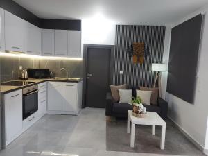 a kitchen and living room with a couch and a table at Golden sand 4 in Ialysos +3 photos