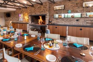 a dining room with a long table and a fireplace at Windhoek Game Camp in Lafrenz Township