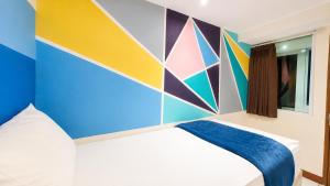 a bedroom with a bed with a colorful wall at Subwow Hostel in Bandung
