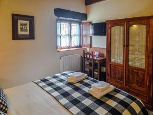 a bedroom with a bed with two towels on it at Posada La Solana Santillana del Mar in Santillana del Mar