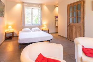 a room with two beds and a couch and a window at Le Studio - Ancienne Cave in Patrimonio