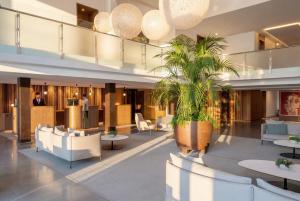 a lobby of a hotel with a palm tree at Iberostar Selection Playa de Muro Village in Playa de Muro