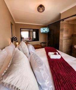 a bedroom with a bed with a red blanket on it at Rudman's Private Love Nest in Boksburg +9 photos