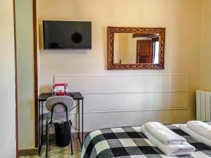 a bedroom with a mirror and a bed and a chair at Posada La Solana Santillana del Mar in Santillana del Mar