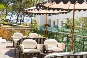 a row of chairs and tables with an umbrella at Iberostar Selection Playa de Muro Village in Playa de Muro