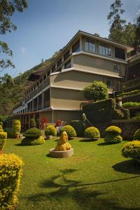a building with a statue in the middle of a garden at Abad Copper Castle Resort in Munnar