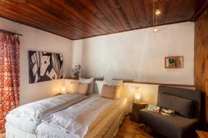 a bedroom with a bed and a chair at Chambres d'hôtes le Clou in Thiézac