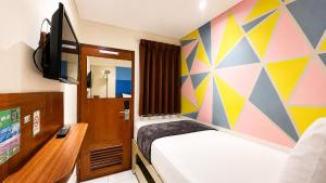a small room with a bed and a tv at Subwow Hostel in Bandung +29 photos