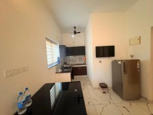 a kitchen with a refrigerator and a table in it at Zensta Residency in Cochin