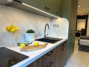 a kitchen counter with a sink and a cutting board at NOBILTON Dębki in Dębki