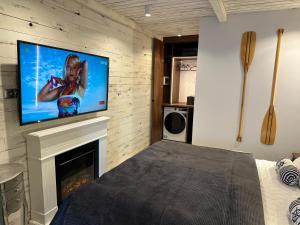 a bedroom with a fireplace with a television on a wall at NOBILTON Dębki in Dębki