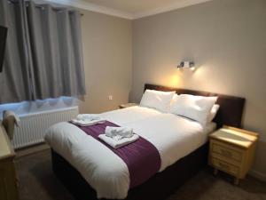 a bedroom with a bed with two towels on it at The Paddington House in Warrington