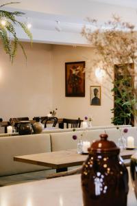 ein Restaurant mit Tischen, Sofas und Blumen an der Wand in der Unterkunft Blanckthys Hotel Voeren in Voeren