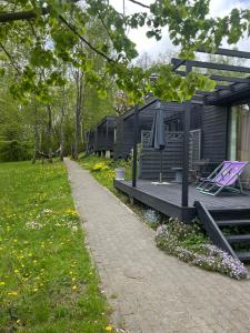 eine Hütte mit Terrasse und Sonnenschirm in der Unterkunft Koziula - Domki i Leśne SPA na Kaszubach in Przywidz