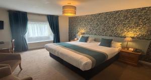 a bedroom with a large bed with blue curtains at Best Western Valley Hotel in Ironbridge +113 photos