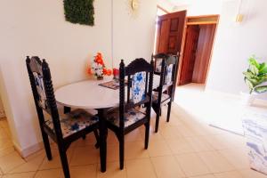 a dining room table and chairs in a room at The Nest Apartment Darad in Ukunda Airport +2 photos