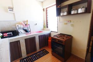 a small kitchen with a stove and a sink at The Nest Apartment Darad in Ukunda Airport