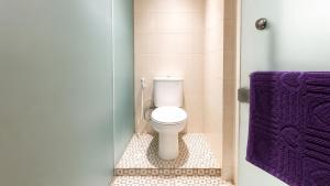 a bathroom with a toilet and a purple towel at Subwow Hostel in Bandung